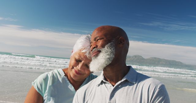 Senior couple embracing on a sunny beach, enjoying retirement and the peaceful sea view. Capturing love, happiness, and a sense of tranquility, ideal for articles or advertisements focused on retirement, life insurance, travel, or health and wellness for elderly couples.