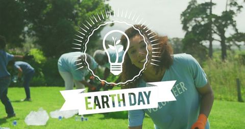 Volunteer Team Collecting Litter in Park on Earth Day with Smiling Woman Wearing Gloves