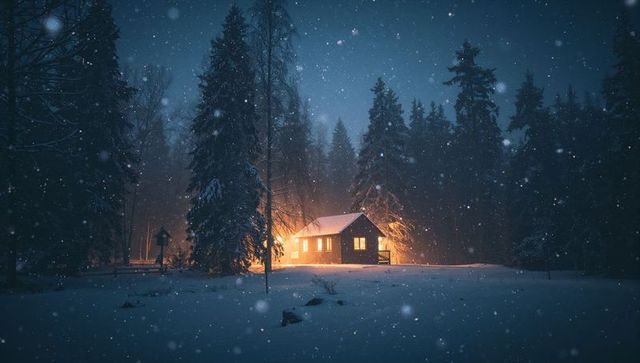 Cozy Wooden Cabin Glowing in Snowy Pine Forest at Night with Warm Lit Windows
