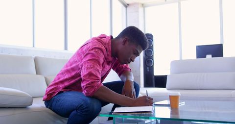 Focused African American Man Writing in Modern Office Lounge
