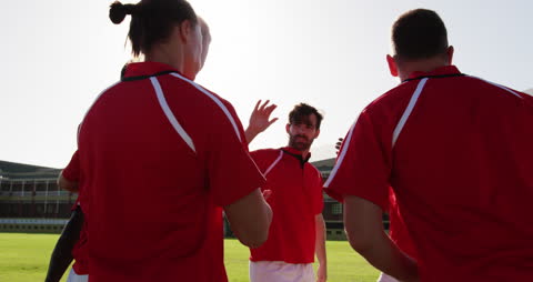 Rugby Team Huddling on Field Under Sun