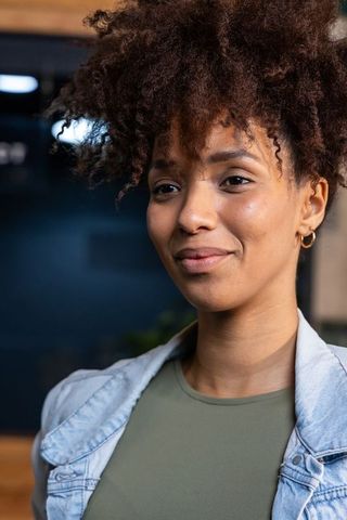 Warm approachable african american professional woman portrait in modern coworking space