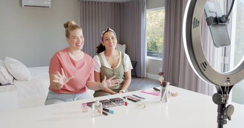 Diverse friends shooting makeup video tutorial with ring light