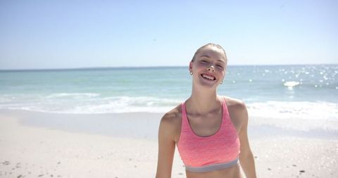 Smiling Young Woman Exercising on Sunny Beach
