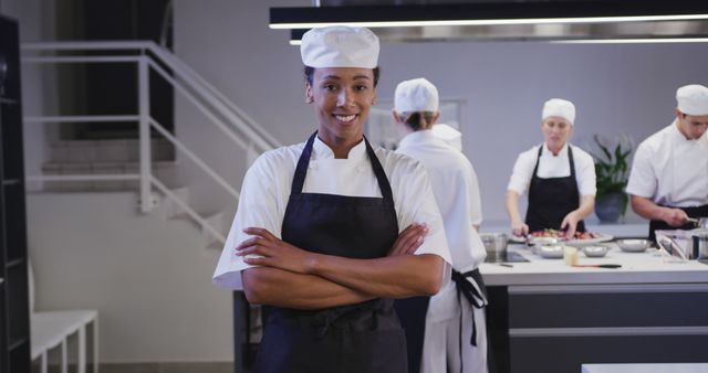 Confident Chef in Professional Kitchen with Team Cooking in Background - Download Free Stock Images Pikwizard.com