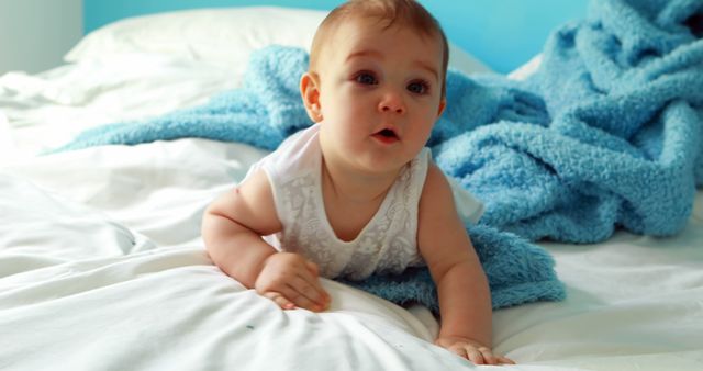 Cute baby girl playing on bed in bedroom