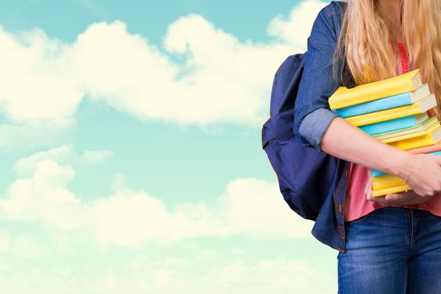 Blonde student is holding a stack of books while wearing a backpack against a cloudy blue sky. Scene conveys a sense of education and learning with an outdoorsy, carefree vibe. Ideal for use in educational content, promotional material for schools, back-to-school campaigns, and educational blogs.