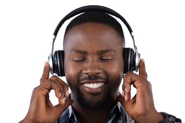 Happy man listening to music on headphones against white background