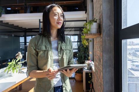 Professional Woman in Modern Office Overlooking Cityscape