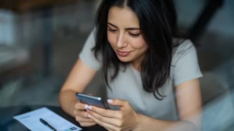 Woman Verifying Information on Phone in Modern Café Setting