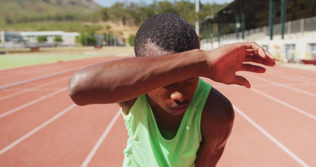 Exhausted Athlete Wiping Sweat After Intensive Training on Track - Download Free Stock Images Pikwizard.com