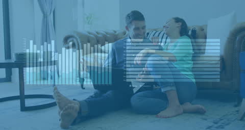 Couple Analyzing Data with Laptop and Graph Overlay in Cozy Home