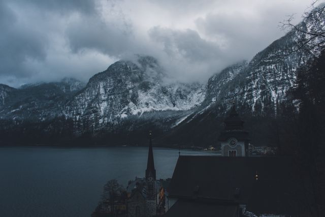 Snow-capped Mountains and Serene Lake with Village Church at Dusk - Download Free Stock Photos Pikwizard.com
