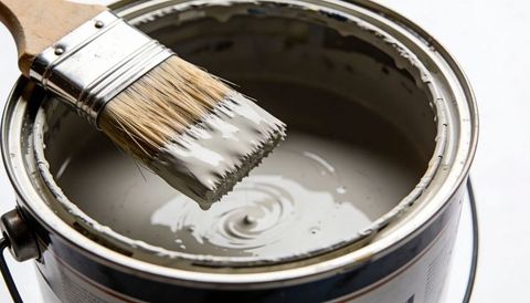 Closeup Flat Brush Dipping into Light Gray Paint Can Creating Smooth Ripples