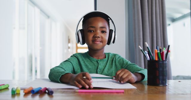 Portrait of african american boy wearing headphones talking looking at the camera. distant learning and online education concept