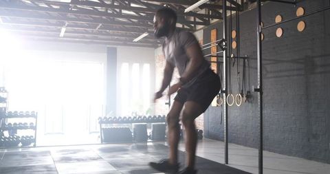 African American Athlete Jumping for Strength in CrossFit Gym
