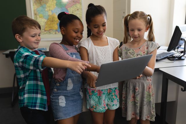 This image shows a diverse group of schoolchildren gathered around a tablet in a classroom, engaging in interactive learning. Ideal for educational content, technology in education, teamwork, and diversity in schools.