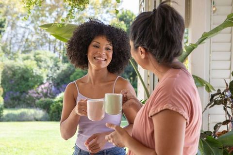 Diverse friends enjoying coffee and conversation on sunny porch