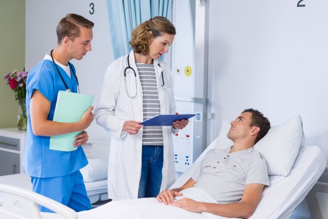 Smiling doctors talking to patient in hospital bed