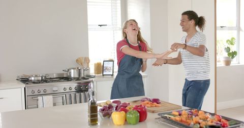 Joyful Couple Dancing and Cooking in Bright Kitchen