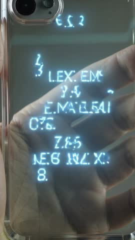 Tilting smartphone in clear case revealing glowing cyan glyphs as finger traces vertical screen