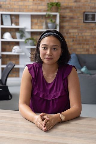 Asian woman in modern loft office with safety helmets background