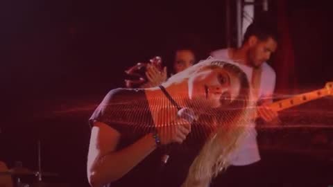 Singer Leaning Into Microphone During Live Band Performance with Red Light Trails