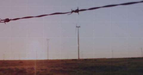 Barbed Wire Fencing with Sunset Over Open Landscape - Download Free Stock Images Pikwizard.com