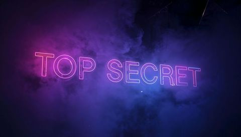 Glowing neon top secret sign illuminating magenta purple blue smoke revealing stage rigging