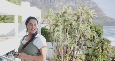 Woman enjoying scenic oceanside view on balcony