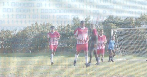 Local soccer players running and defending goal with referee and goalkeeper, scanlines overlaying