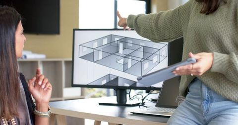 Diverse female team collaborating over 3d architectural floor plan on monitor in office