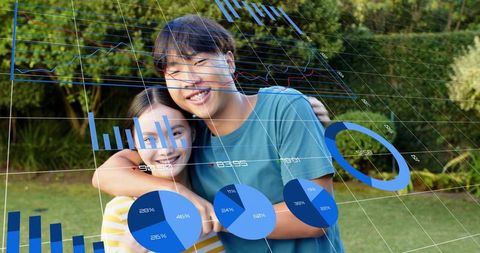 Asian young couple embracing while viewing holographic data visualizations in garden
