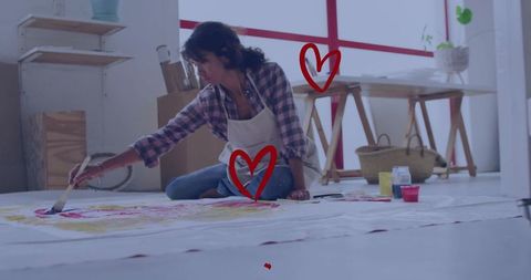 Artist painting on workshop floor with brush and pigments