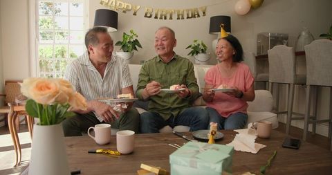 Happy seniors enjoying birthday celebration with cake and laughter