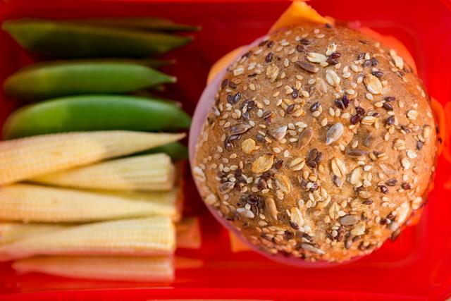 Close-up of burger and vegetables in open lunch box