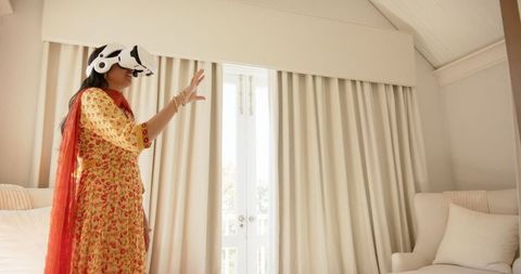 Indian Woman Using VR Headset at Home Immersed in Virtual Experience