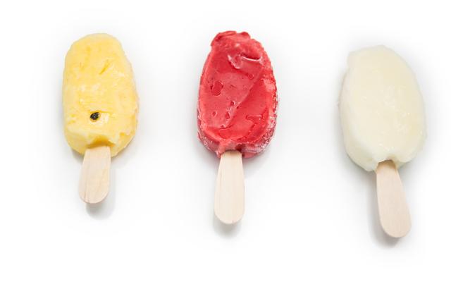 Three different flavors of ice lollies arranged in a row on a white background. Ideal for use in advertisements for frozen desserts, summer-themed promotions, or food blogs showcasing refreshing treats.