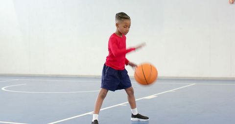 Youthful Energy on the Court: Child Dribbling Basketball Indoors