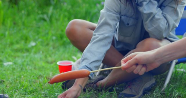 Person Roasting Sausage Over Open Flame at Outdoor Picnic - Download Free Stock Images Pikwizard.com