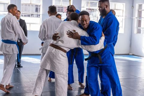 Judokas Celebrating Victory with Embrace on Mat