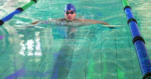 Swimmer performing breaststroke in competition pool