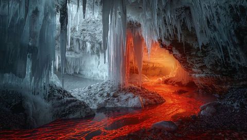 Icy cavern with flowing lava stream creating dramatic contrast