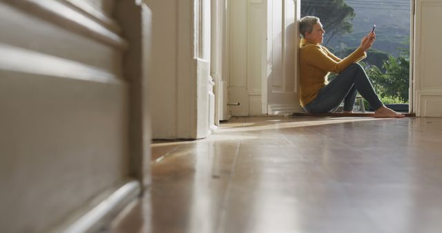 Senior Woman Relaxing by Doorway Using Smartphone - Download Free Stock Images Pikwizard.com