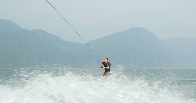 Smiling Woman Enjoying Waterskiing on Misty Mountain Lake - Download Free Stock Images Pikwizard.com