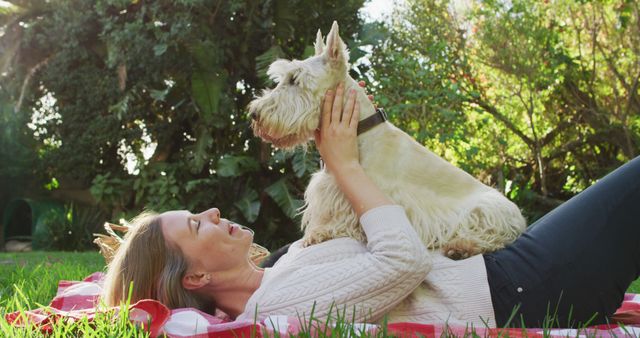 Happy caucasian woman playing with her dog in the garden. lgbt relationship and lifestyle concept