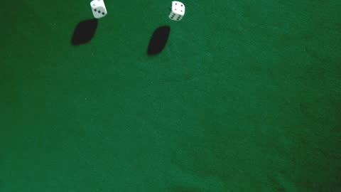Rolling Dice Falling on Green Casino Table