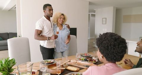 African American Friends Toasting at Home Dinner Table