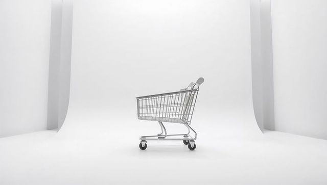 Sleek chrome shopping cart sitting on white cyclorama backdrop, minimalist retail concept
