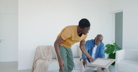 Father and son unpacking together in cozy living room